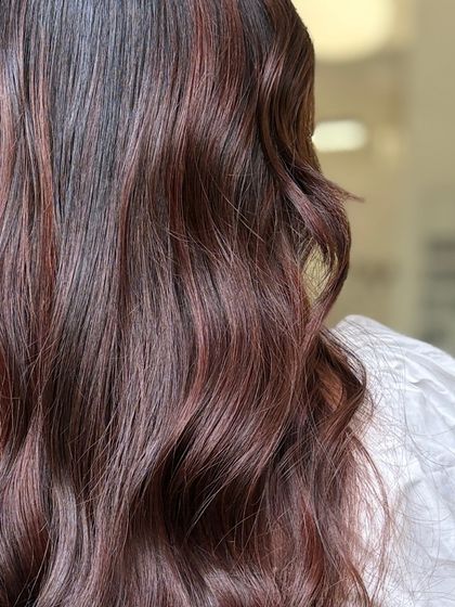 A close-up of the subtle red tones, showing how they add warmth and richness to the hair.