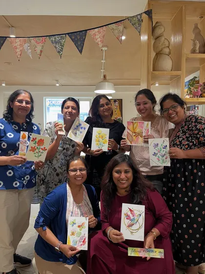 A group of ladies proudly showing off the beautiful floral watercolor cards they created in a workshop. It's a wonderful way to spend an afternoon with friends.