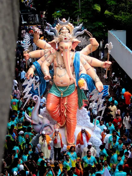 A powerful view of a multi-armed Ganesh idol making its way through the city, showcasing the incredible artistry and devotion involved in the festival.