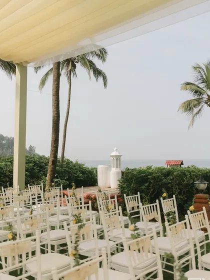 A wide view of the guest seating for the seaside Haldi, with white chairs looking out towards the ocean.