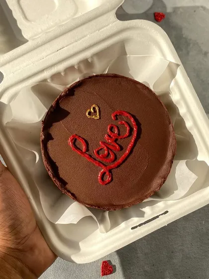 This Strawberry Chocolate bento cake, with "Love" piped in red, is a perfect Valentine's treat. The rich chocolate and fresh strawberry flavor is a classic combination.