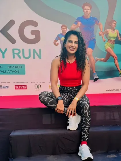 A fitness instructor poses on the stage of the UKG Unity Run. My team includes certified and energetic instructors who lead warm-ups and cool-downs.