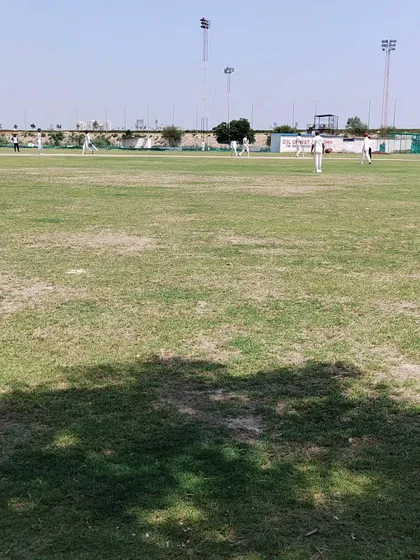 A view of our main cricket ground during a weekly practice match. We have a lush, well-maintained grass field to ensure you get experience in real match conditions, which is a core part of our residential program.