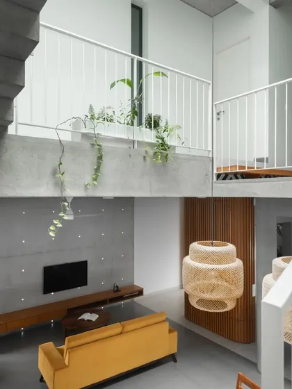 A view from the staircase landing looking down into the living area. This split-level perspective highlights the home's verticality and the interplay of volumes, with the bridge connecting the upper floors.