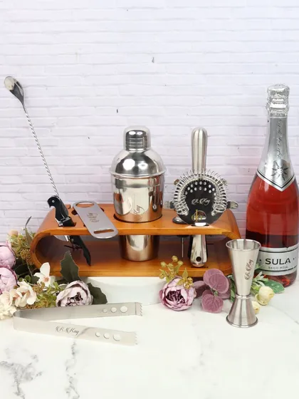 Unwind in style with our luxe bar set. This set includes a shaker, strainer, jigger, and other essentials on a wooden stand, perfect for home mixology.