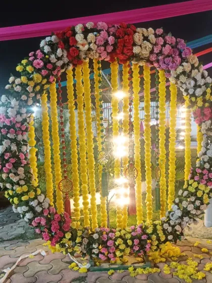 A beautiful and trendy photo booth is a must for any celebration. Here, I designed a large circular floral ring with hanging marigold garlands, creating the perfect backdrop for guests to capture memories at an outdoor festival.