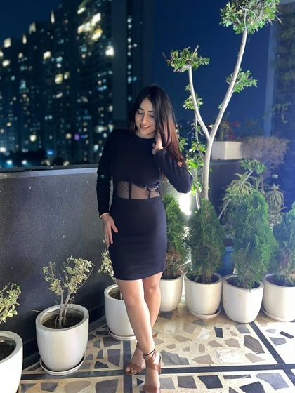 A final look at the sophisticated black party dress. The city lights in the background create a beautiful bokeh effect.