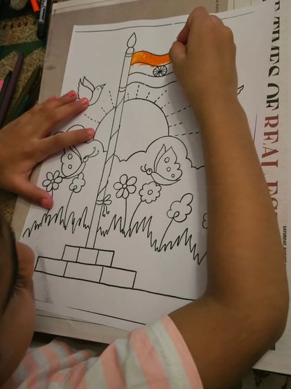 Another young artist adding the saffron color to the Indian flag in her Independence Day artwork.