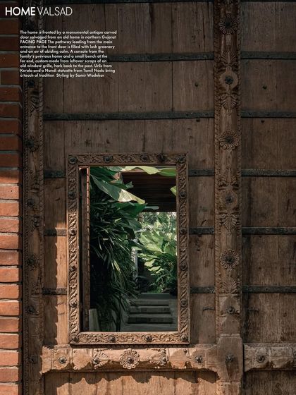 This feature shot focuses on the antique carved door, with the mirror reflecting the garden path. It's a beautiful illustration of how we used reflective surfaces to amplify the presence of the landscape throughout the property.