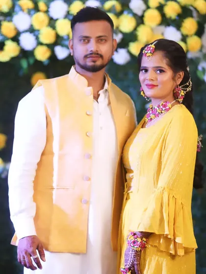A classic portrait of the couple, their faces glowing with happiness and haldi.