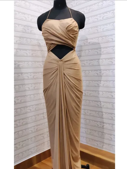For a bold and modern statement, I designed this fusion gown with a daring waist cut-out and an elegantly draped silhouette. The halter neck and ruched detailing are crafted to flatter the figure, making it a unique piece of custom evening wear that combines confidence with grace.