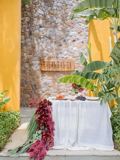 The Orchard Table is positioned to feature our wooden 'Anvaya' sign in the background, blending our brand identity with the natural beauty of the setting.