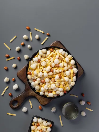 A light, savory mix featuring puffed rice and peanuts. The neutral grey background ensures the product's colors and textures are the primary focus for this packaging shot.