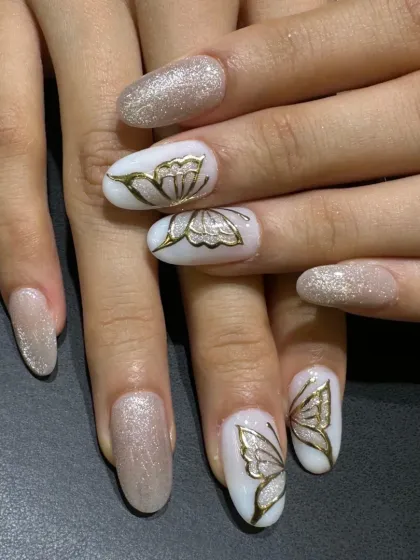 A close-up of the elegant cat-eye and butterfly set, showing the shimmering base and the fine lines of the golden butterfly art.