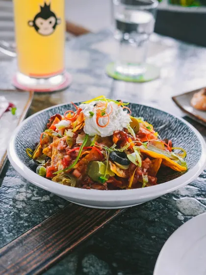 A bowl of loaded nachos is the perfect companion to a cold beer. It's a classic combination for a relaxed evening.