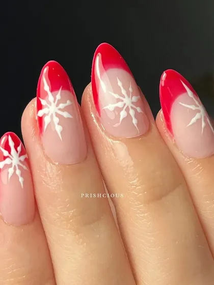 A close-up of the red French tip and snowflake nail art. The clean lines and festive design make this a simple yet stunning holiday choice.
