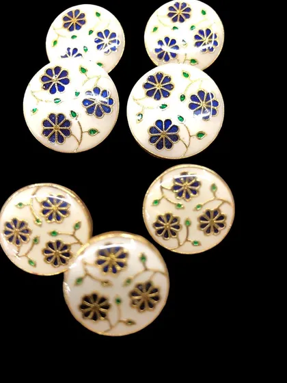 These handmade buttons feature a beautiful blue floral vine pattern on a white enamel base. The delicate design is ideal for adding a classic, refined look to kurtas and blouses.