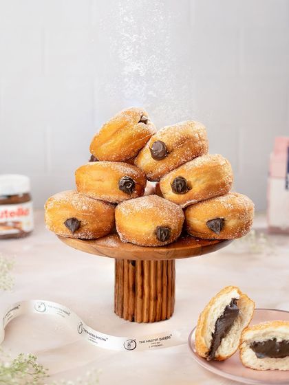 A tower of our classic Berliners, generously filled with rich chocolate and dusted with powdered sugar. These pillowy soft donuts are an irresistible treat.
