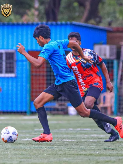 An SG5 player in our blue kit, moving the ball forward with purpose during a First Division match.