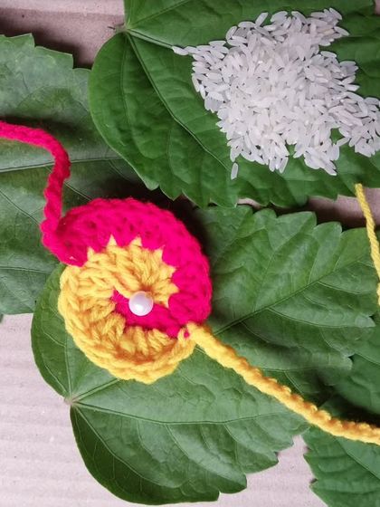 A two-toned pink and yellow crochet rakhi. The color combinations are endless and fully customizable.