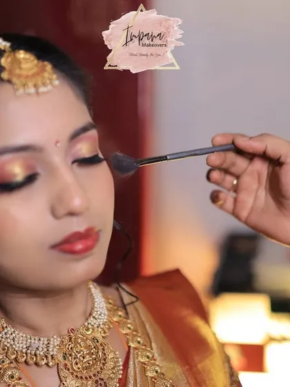 The final touch. Here, I am applying a soft powder to set this bride's Muhurtham makeup. This action shot captures the precision and care I put into creating a look with glowing skin and captivating eyes that feels both special and comfortable.
