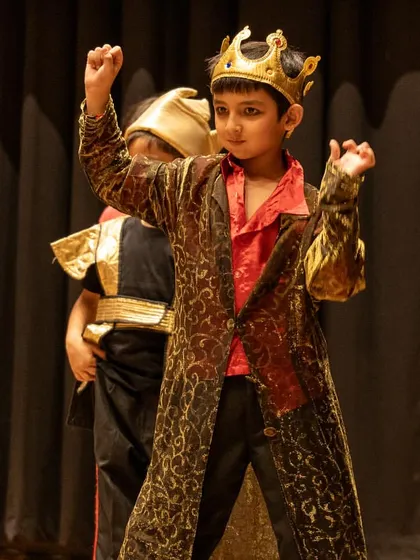 Embodying royalty in 'The Emperor's New Clothes'. This young actor demonstrates powerful posture and character expression, key performance skills we develop to help children communicate personality and status on stage.