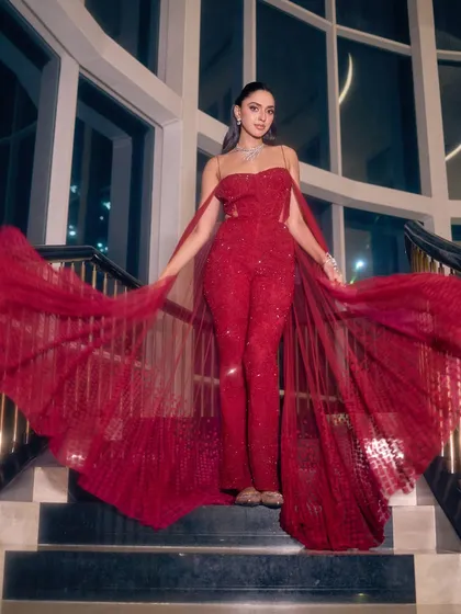 For the modern bride, a reception look can be bold and dramatic. This sparkling red jumpsuit with a flowing cape is a fantastic alternative to a traditional gown, offering a chic and unforgettable silhouette.