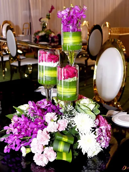 An elegant floral centerpiece for a formal dinner. I used a mix of purple orchids, pink roses, and white chrysanthemums to create a sophisticated and colorful arrangement.