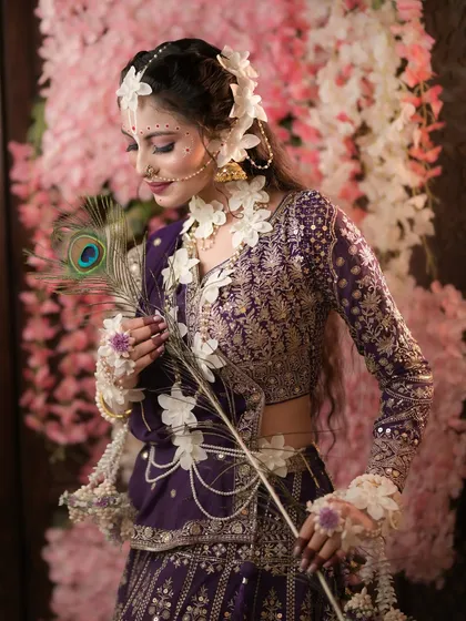 A thoughtful pose with the peacock feather, adding a layer of storytelling to the image.