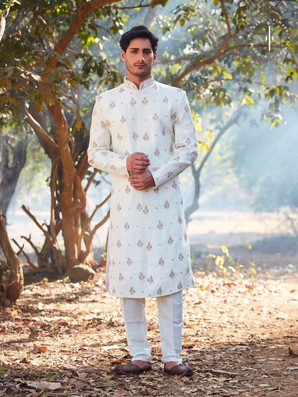 An elegant off-white sherwani with delicate, spaced-out embroidery. This outfit is all about understated sophistication, perfect for a daytime wedding or an intimate ceremony. The clean lines and subtle details ensure you look sharp and timeless.