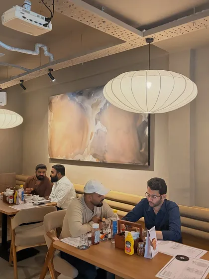 A wider view of the Sidewalk cafe in Lucknow, showing two of my large-scale abstract paintings. They help to define different zones within the large, open-plan space.