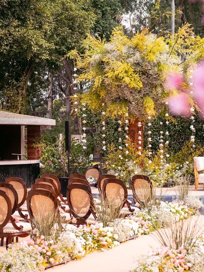 Another view of the charming outdoor wedding decor, showing the seating arrangement and the natural beauty of the venue.