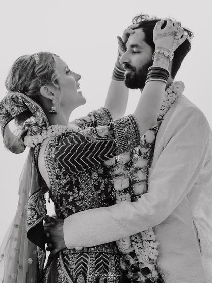 A playful, candid black and white moment from a beach wedding.