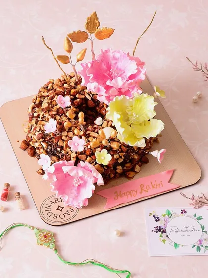 A closer look at the Almond Praline Cake for Rakhi, showing the crunchy texture and beautiful floral decorations.