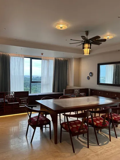 The dining area in the Embassy Lake Terraces project is both formal and inviting. We used a solid wood dining table and chairs with rich red patterned upholstery, complemented by custom cabinetry and large windows that fill the space with light.