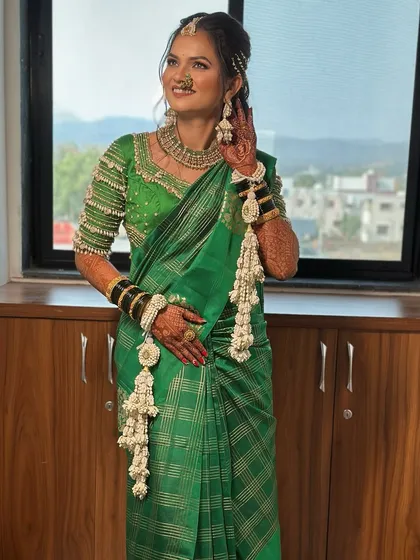 The bride looks radiant in her green saree and our custom white floral jewellery. The set includes a maang tikka, earrings, and matching kalire.