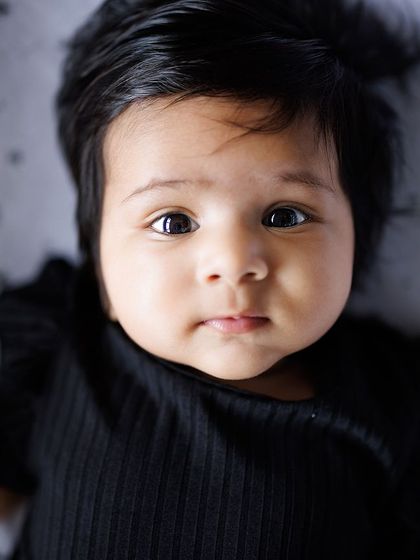 The deep, soulful eyes of a baby are simply mesmerizing. This close-up shot on a starry background captures a moment of quiet contemplation and pure innocence.
