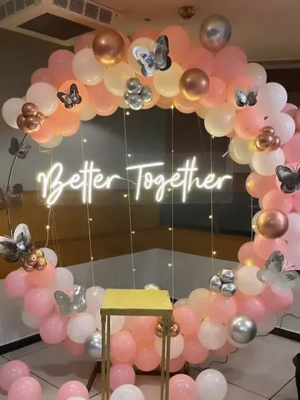 Celebrating your journey together is our specialty. This 'Better Together' ring backdrop uses a soft palette of pink, white, and rose gold balloons, accented with butterfly details and fairy lights for a whimsical and romantic feel.