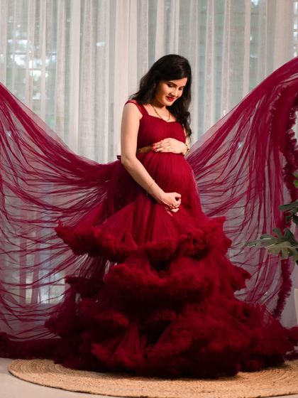 A dramatic studio shot with the red gown's wings spread wide, creating a breathtaking butterfly effect. This is a true statement portrait.
