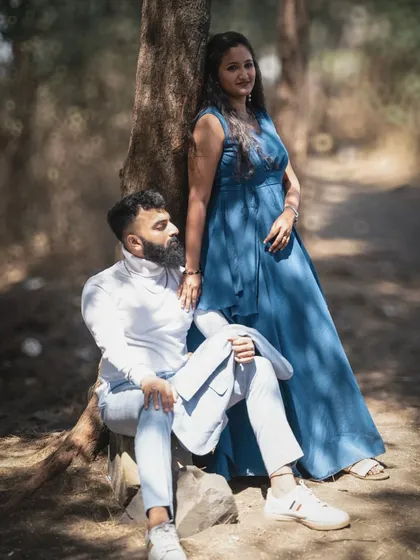 A stylish pre-wedding portrait of a couple posing in a forest setting, showcasing their modern and chic style.