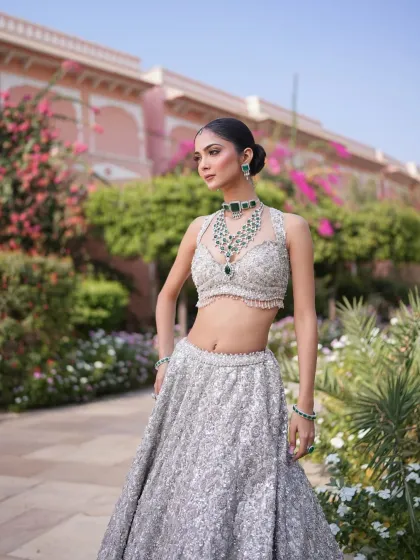 A portrait in a beautiful garden setting. The silver lehenga and emerald jewelry create a stunning contrast against the pink flowers, a combination I love to style.