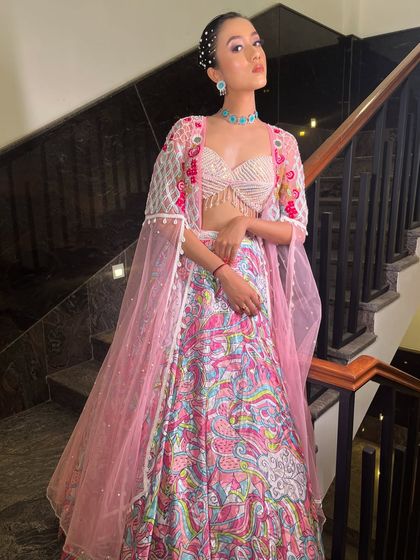 A series showcasing our "soft girl era" lehenga. The printed skirt, pearl-fringed blouse, and sheer embroidered jacket make it a dreamy and feminine choice for a day event.