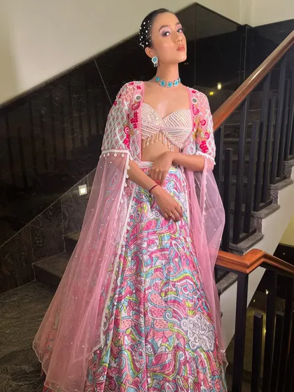 A series showcasing our "soft girl era" lehenga. The printed skirt, pearl-fringed blouse, and sheer embroidered jacket make it a dreamy and feminine choice for a day event.