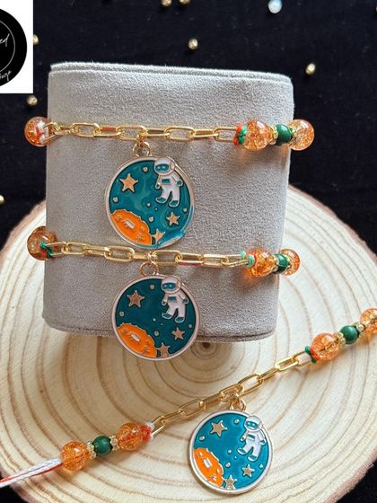 For the little astronaut who dreams of the stars. This cosmic-themed rakhi features an astronaut charm on a beaded bracelet, perfect for an adventurous spirit.