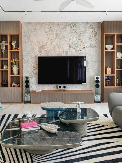 The living room from our 'Urban Oasis' project, featuring a bold zebra-print rug that anchors the space. The design mixes different textures and shapes, from the curved grey sofa to the geometric coffee tables.