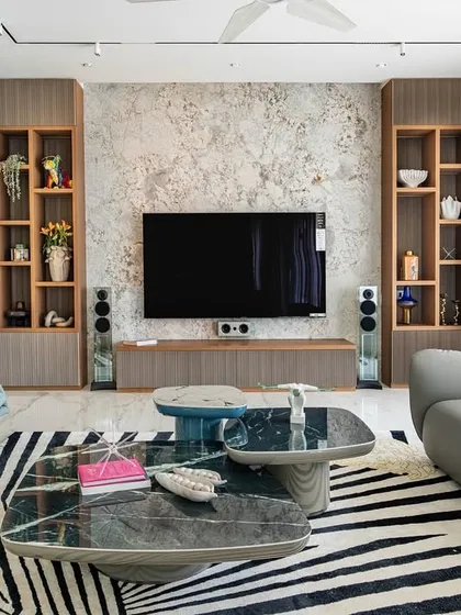 The living room from our 'Urban Oasis' project, featuring a bold zebra-print rug that anchors the space. The design mixes different textures and shapes, from the curved grey sofa to the geometric coffee tables.
