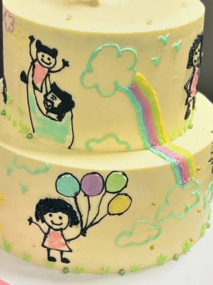 I just love how this doodle cake turned out. The two-tier design is covered in hand-painted drawings that tell a unique family story, making it incredibly personal.