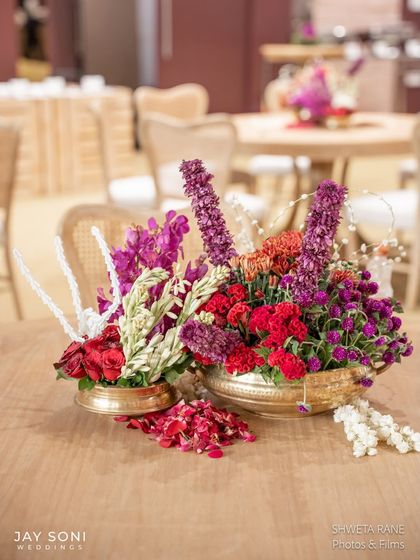 A centerpiece featuring a mix of vibrant flowers and delicate pearl-like strings, adding a touch of whimsy and elegance.