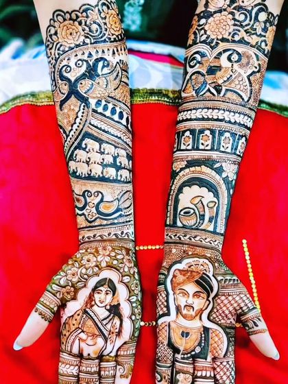A stunning portrait mehendi with great detail. The bride's jewelry and the groom's turban are drawn with precision, and the arms feature elephants and fish motifs.