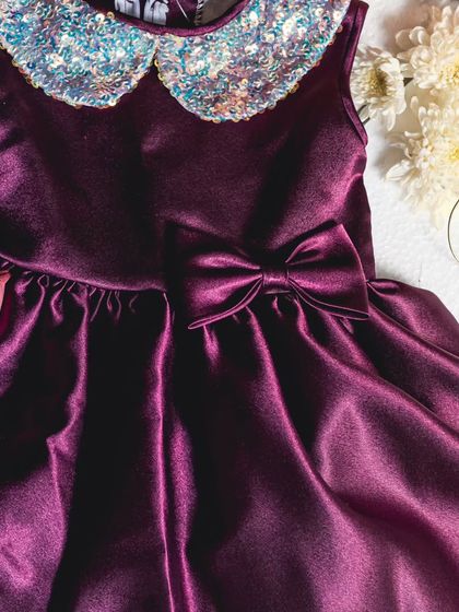 A close-up of the rich wine-colored satin and sparkling sequin collar. I focus on high-quality materials to ensure every dress not only looks stunning but feels wonderful to wear.